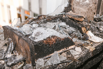 Aftermath of devastating fire, showcasing charred debris and broken glass, symbolizing destruction and loss. Impactful image is ideal for conveying themes of disaster, rebuilding or power of nature