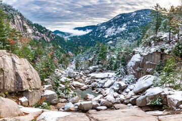 Snowy mountain valley, autumn hues, and rugged rocks
