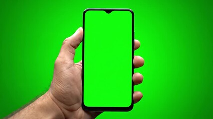Realistic hand holding smartphone with green screen display, isolated background, perfect for mobile app presentation, digital mockup, and technology advertising projects.