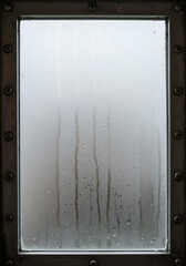 An emotional glimpse through a rain streaked window like a watercolor painting evoking peace with a metal frame and soft