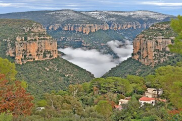 Mountain valley shrouded in a cloud;  rocky peaks