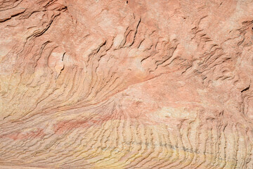 Waves of layers of orange stone eroded out of rock layers of orange sandstone rock wall, patterns and texture in nature, Zion National Park, Utah
