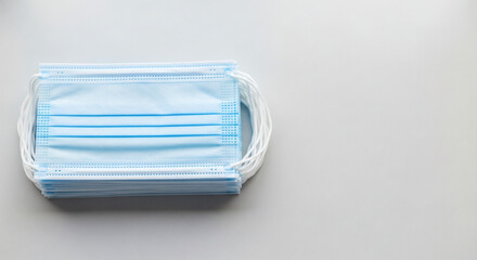 Stack of blue disposable medical face masks for protection against viruses and pollution.