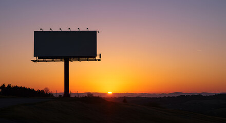 A silent promise of tomorrow a blank billboard awaits inspiration as the sun dips below the horizon creating warm orange