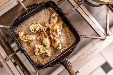 Chicken pieces frying in a hot skillet