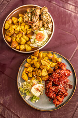 Two plates of fried chicken, potatoes, and salad