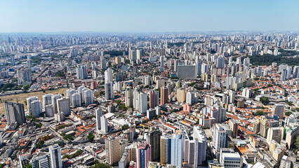 Fototapeta premium Drone registra o centro de São Paulo, destacando prédios imponentes, ruas movimentadas e a vida urbana que define a metrópole.