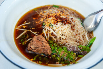 Close up Braised chicken noodle soup on wooden table ready to eat