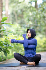 Healthy Asian woman in sportswear do yoga at the park. Moslem woman with sportwear.