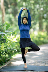 Healthy Asian woman in sportswear do yoga at the park. Moslem woman with sportwear.
