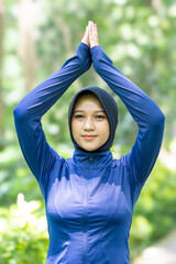 Healthy Asian woman in sportswear do yoga at the park. Moslem woman with sportwear.