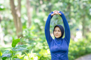 Healthy Asian woman in sportswear do yoga at the park. Moslem woman with sportwear.