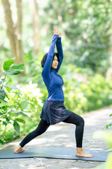 Healthy Asian woman in sportswear do yoga at the park. Moslem woman with sportwear.