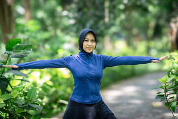 Healthy Asian woman in sportswear do yoga at the park. Moslem woman with sportwear.