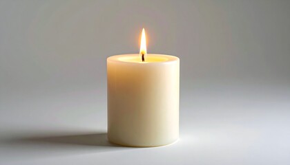 A close-up shot showcases a burning candle. The flame illuminates, casting soft shadows on a white, neutral backdrop. Its a calm scene