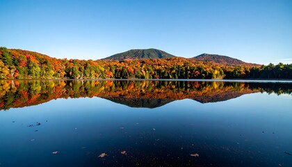 Calm lake reflecting autumn foliage and mountain
