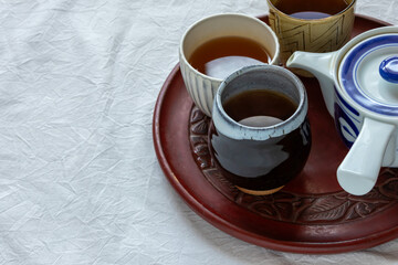お盆に乗せたお茶の入った湯飲み