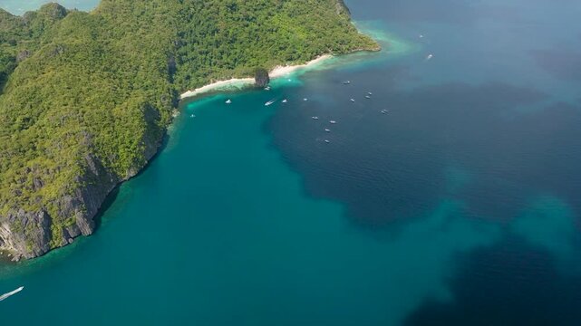 Tourist boats over the ocean in Seven Commandos Beach and Papaya Beach in El Nido, Palawan. Philippines.