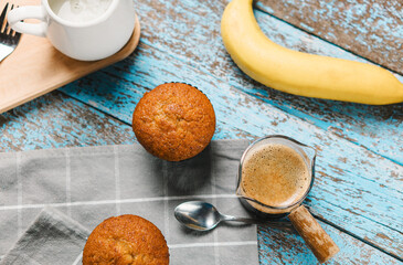 A cup of hot black coffee, Espresso, fresh baked muffins. Banana cupcake close-up as dessert for coffee break. Top view. refreshing morning and day