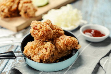 Crispy Fried chicken with tomato sauce on grunge background table. Fast food unhealthy.