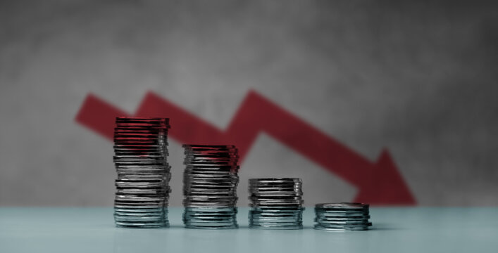 Downward red arrow with shrinking stacks of coins, depicting global recession, economic downturn, and significant financial loss.