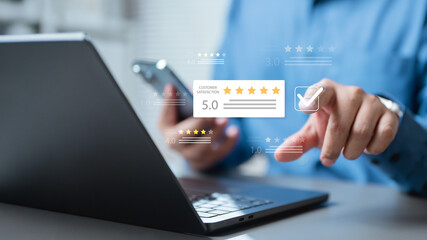 Close-up of businessman using laptop and smartphone with customer satisfaction rating overlay, symbolizing online review, service quality, feedback management, and client trust.