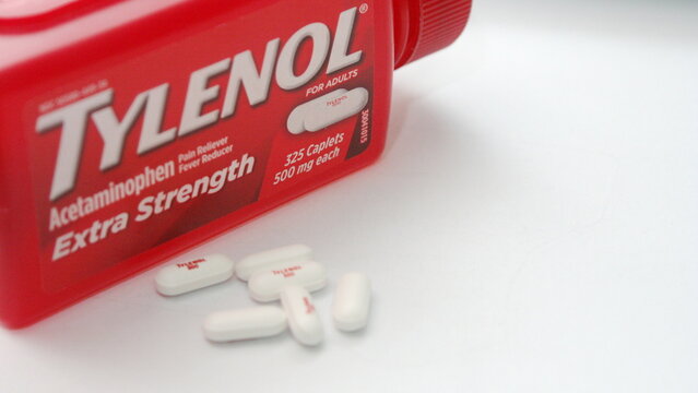 WA-AMERICA - SEP 11 2025 : A close-up shot of a red Tylenol Extra Strength bottle and several white caplets on a pristine white background.