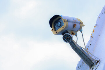 Aged Surveillance Weathered Security Camera Monitoring System Against Clear Blue Sky