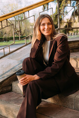 Urban lifestyle. Business break. Cheerful happy relaxed woman enjoying pleasant day with hot tea in paper cup.