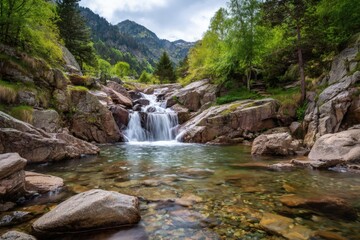Fototapeta premium Mountain waterfall with wild water rushing over rocks and green moss, perfect for nature and outdoor photography.