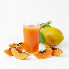 Fresh papaya juice in a glass with sliced papaya and whole fruit on white background.