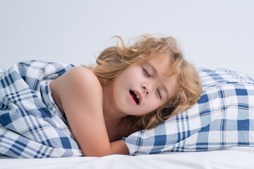 Naklejka premium Yawning child. Kid lying in bed, waking up. Morning awakening, sunny kids bedroom.