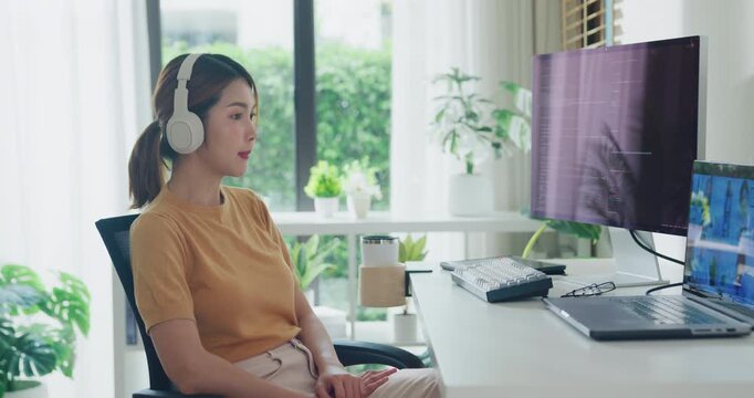 Young Asia female programmer meeting video conference discuss work prompt AI bot IT app program nomad, video game, terminal with coding, user interface, data center on desktop computer at home office.