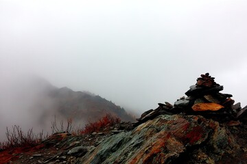 Misty mountaintop with stone cairn