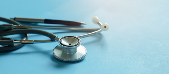 Close up stethoscope and pen on blue background representing about healthcare, medical checkup and diagnosis for  insurance and medicine and patient treatment concept