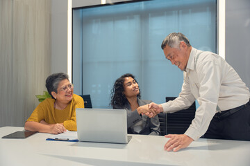 Senior consultant client over agent, broker discussing home sale, medical insurance terms, trust fund investments, meeting at laptop in office.