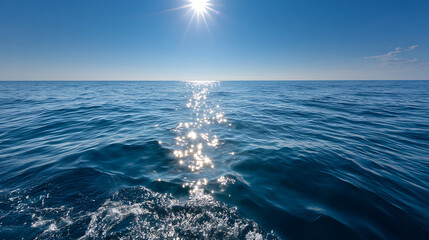 Ocean water under bright sun with sparkling reflections on calm blue sea surface on clear day