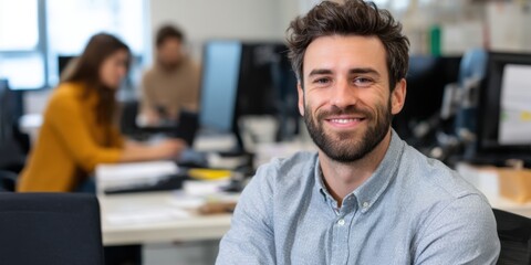 Fototapeta premium Cheerful South American CEO with a beard, looking directly at the camera in an office.