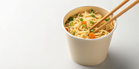 Instant noodle cup with chopsticks and vegetables, warm and appetizing meal ready to eat