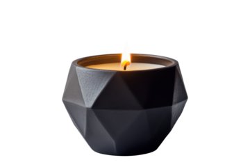 Geometric black candle with a lit flame isolated on transparent background. A lit candle placed inside a geometric black ceramic holder isolated on white background.