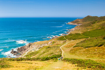 Woolacombe, Devon, England, UK - People walking on the South West Coast Path heading towards Morte Point, on one of the hottest days of the year. © Colin & Linda McKie