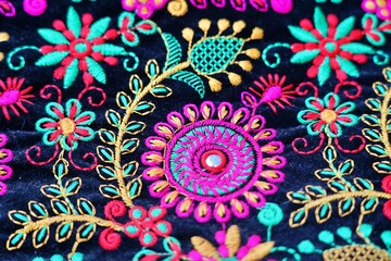 Embroidered floral design on velvet fabric close up