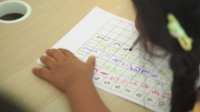Child solving number puzzle at a table