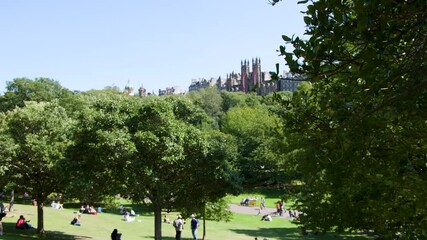 People Relaxing in Edinburgh Park on Sunny Summer Day