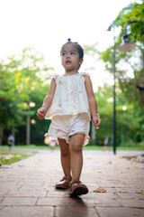 Preschool little asian girl enjoy walking on city pathway public park tree forest