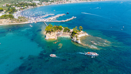 Aerial panorama of Cameo Island Zakynthos Greece surrounded by emerald and deep blue sea with boats cruising near iconic rocky islet © Fineshot