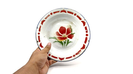 hand holding a vintage enamel plate isolated on white background. in Indonesian known as 
