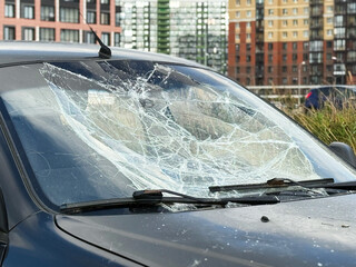 A broken windshield of a car due to burglary, vandalism, theft. Dangerous, careless, unsafe, drunk,...