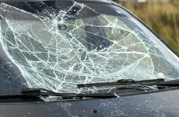 A broken windshield of a car due to burglary, vandalism, theft. Dangerous, careless, unsafe, drunk,...