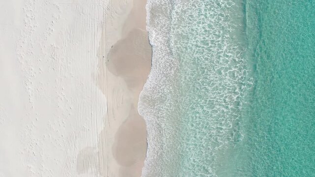 Aerial top down view of foamy waves on white sand Snelling Beach, Kangaroo Island, South Australia